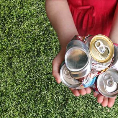 criança a segurar latas de alumínio de acordo com o Radar da reciclagem